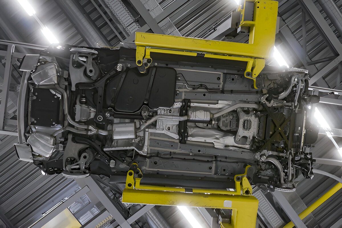 Carro visto de baixo em linha de montagem em posição de inspeção da parte inferior